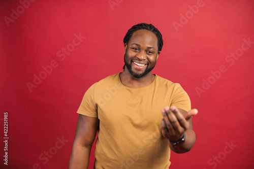Billede på lærred Glad dark skinned man wearing casual shirt shows come on gesture with hands, che