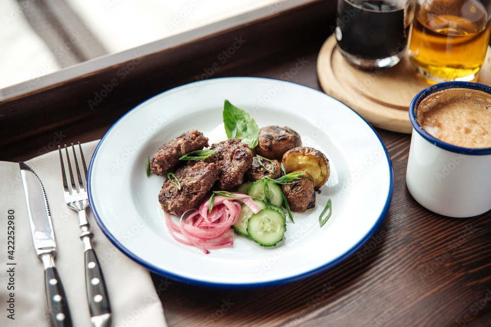 Mini beef cutlets with potato and cucumbers and a mug of coffee Mini beef cutlets with potato and cucumbers and a mug of coffee