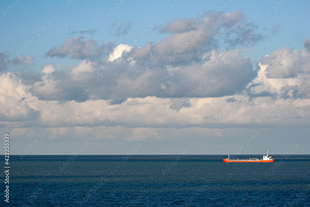 Red cargo ship out at sea off the Kent coast