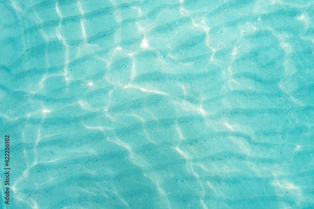  Blue sea ocean, water bright sunlight, and wave sand pattern texture natural background. Top view