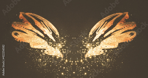 Golden glitter on abstract gold hand painted wings on black background