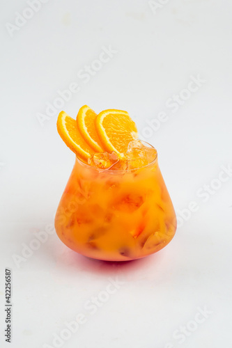 Isolated glass of citrus sweet cocktail with orange slices on the white background photo