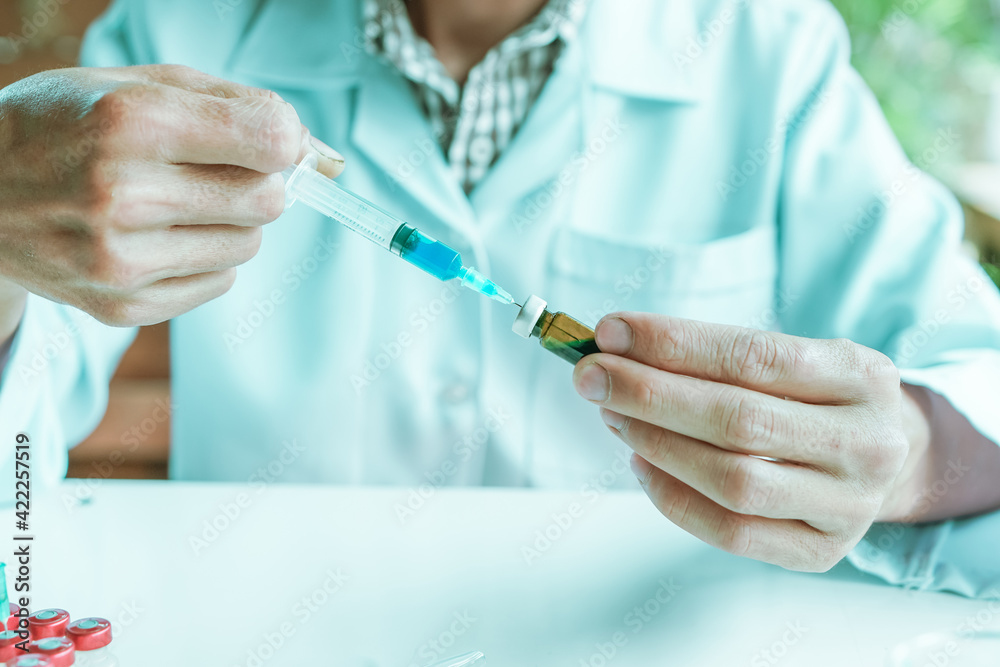 A biomedical research laboratory scientist Not wearing Protective gloves using a syringe to extract a sample chemical A biomedical research laboratory scientist Not wearing Protective gloves using a syringe to extract a sample chemical