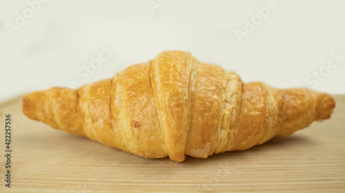 Freshly baked croissants on wooden cutting board, White Background. Crescent-shaped bread originated in France. The popular breakfast menu spread all over the world.