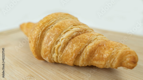 Freshly baked croissants on wooden cutting board  White Background. Crescent-shaped bread originated in France. The popular breakfast menu spread all over the world.