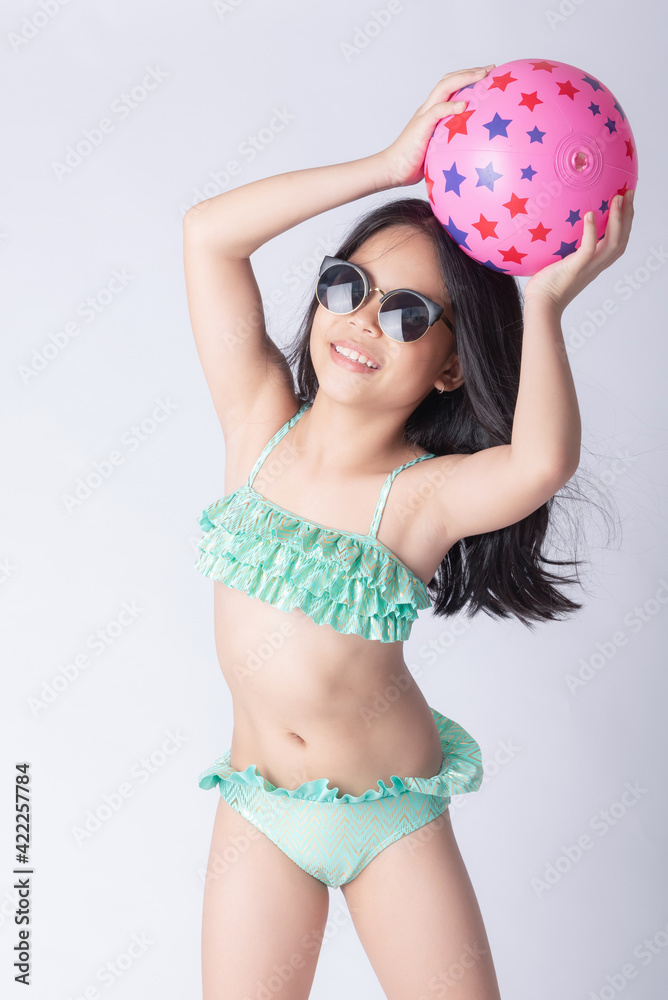 child bikini holding a beach ball. little stylish lady girl in swimsuit,  relaxing isolated white background. lovely photo for advertising,copy space  for text. beach vacation concept. Stock-Foto | Adobe Stock