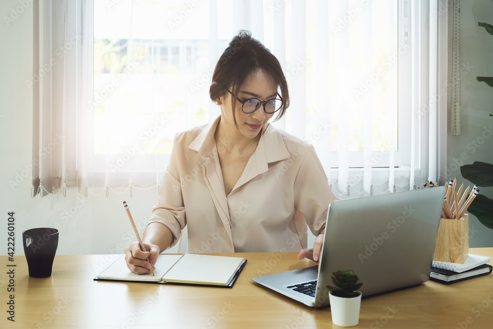 new normal, a businesswoman uses a computer to work for a company Via the internet on your desk at home new normal, a businesswoman uses a computer to work for a company Via the internet on your desk at home