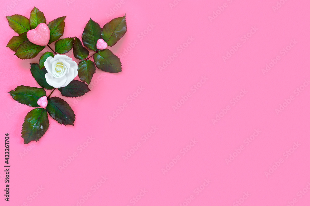Beautiful white roses with green foliage and heart for Valentine's Day on pink paper background. Creative greeting card.