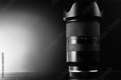 Stylish photo lens with beautiful glare on a black background. With copy space.