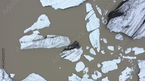 Flying over floating icebergs in Fjallsarlon glacial lagoon, Iceland. Aerial view of melting ice cap as result of global warming and climate change photo