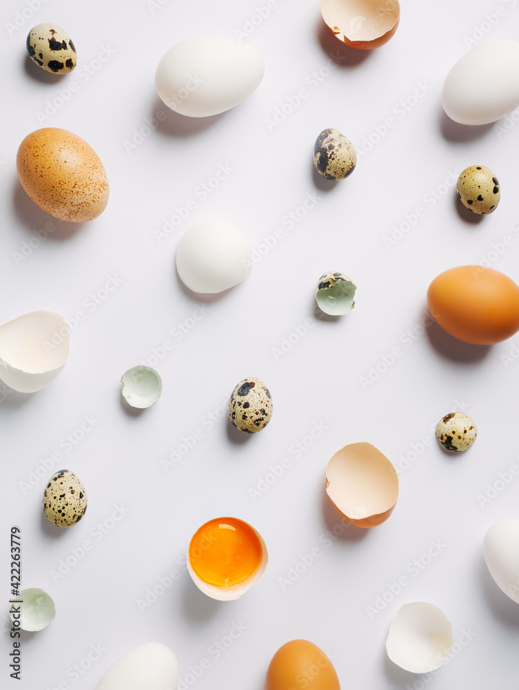 Abstract modern Easter background with various eggshell on bright white background. Contemporary Easter or food art concept. Flat lay, top view.