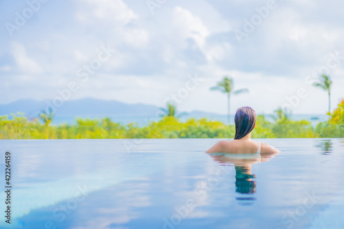 Portrait beautiful young asian woman enjoy around outdoor swimming pool with sea view