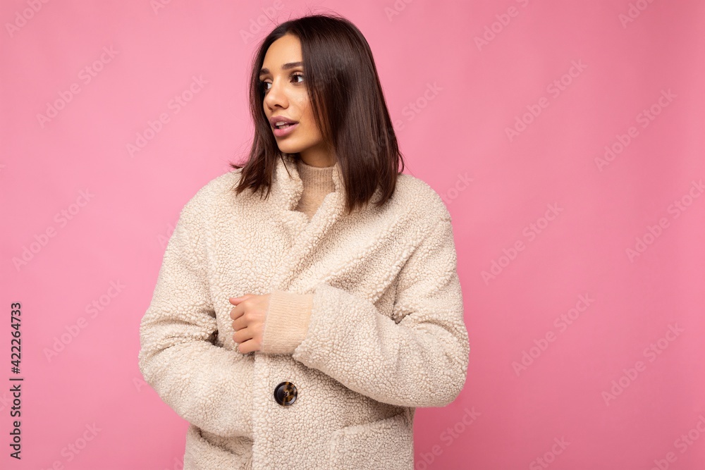 Portrait of attractive self-confident positive good-looking stylish young brunette woman wearing winter beaige warm coat isolated on pink background with free space. Fashion concept Portrait of attractive self-confident positive good-looking stylish young brunette woman wearing winter beaige warm coat isolated on pink background with free space. Fashion concept