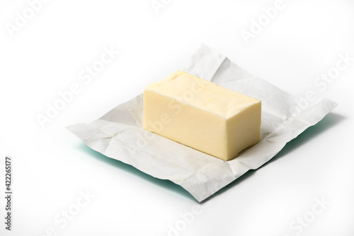 Traditional butter block unwrapped for use as a baking ingredient isolated on white background