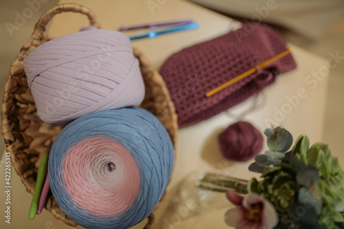 Crochet. Still life of skeins of thread  knitted basket  crochet hooks. Home hobby