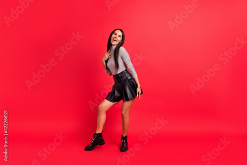 Full size photo of young happy cheerful pretty laughing girl hold hand chest look copyspace isolated on red color background