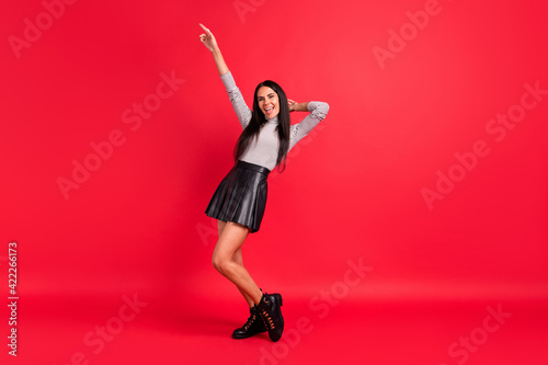Full length photo of charming stunning young woman point finger up dance party isolated on red color background