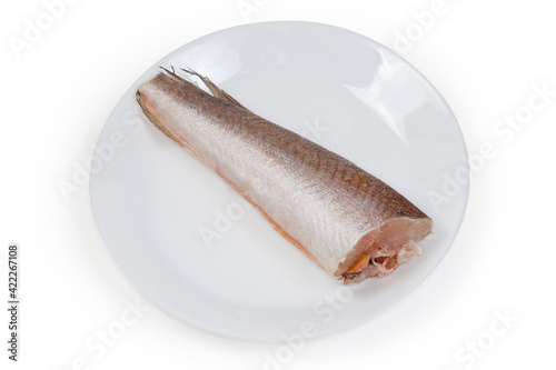 Defrosted uncooked Argentine hake cleaned from fish scales on dish