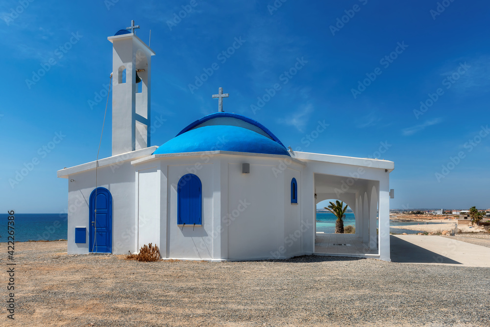 White and blue chapel by the sea in Cyprus, Mediterranean sea coast. 