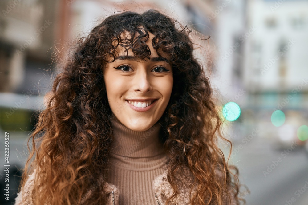 Fototapeta premium Young hispanic woman smiling happy standing at the city