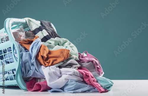 Photo Heap of dirty clothes and laundry basket