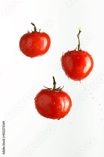 Red tomatoes in spray of water. Juicy tomato with splash on white background.