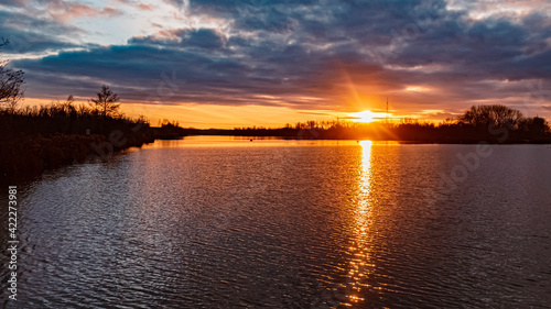 Beautiful sunset with reflections and dramatic clouds near Plattling, Isar, Bavaria, Germany