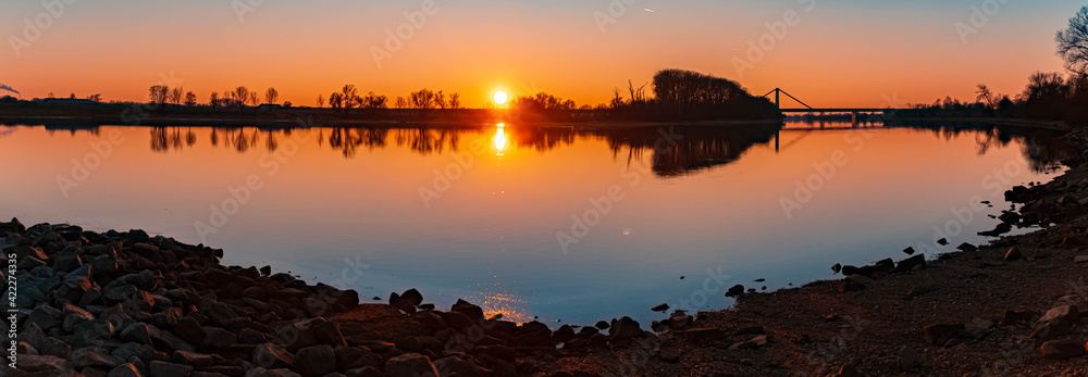 High resolution stitched panorama of a beautiful sunset with reflections near Metten, Danube, Bavaria, Germany