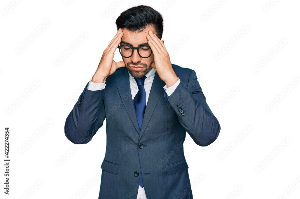 Hispanic man with beard wearing business suit and tie suffering from headache desperate and stressed because pain and migraine. hands on head. Hispanic man with beard wearing business suit and tie suffering from headache desperate and stressed because pain and migraine. hands on head.