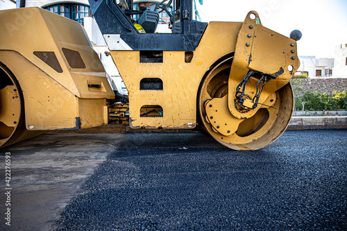 Close up on the road roller working on the new road construction site.