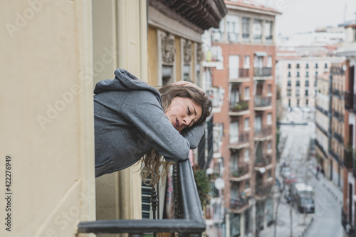 Young beautiful woman looking sad and depressed on a balcony in a depression concept. © SB Arts Media