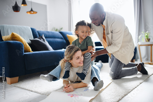 Multi ethnic family with two small children having fun at home.