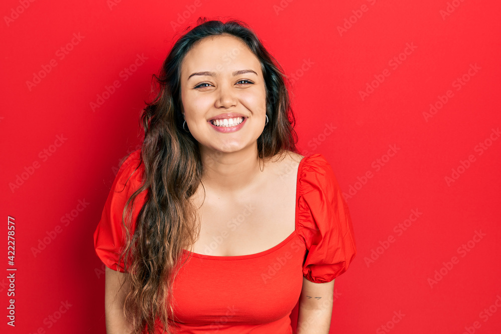 Young hispanic girl wearing casual clothes looking positive and happy standing and smiling with a confident smile showing teeth