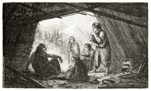 Ostiak family indoor in a hut giving glimpse to a mountain landscape in Siberia, Russia. Ancient grey tone etching style art by Trichon, Le Tour du Monde, 1862