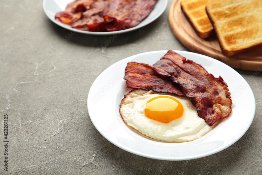 Eggs and bacon for breakfast on grey background. English breakfast with copy space. Eggs and bacon for breakfast on grey background. English breakfast with copy space.