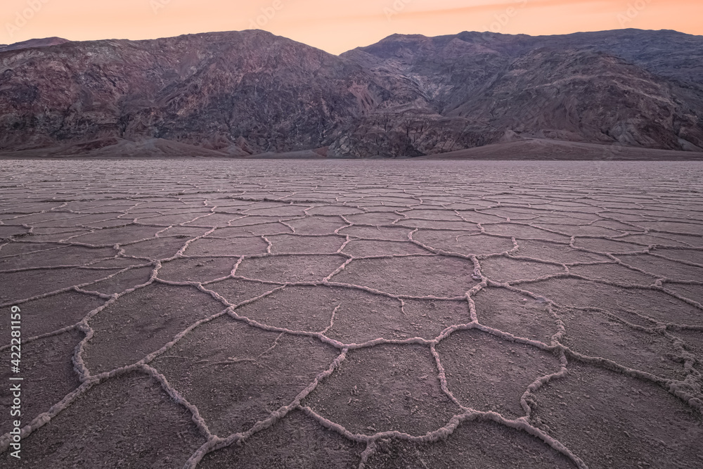 Fototapeta premium Beautiful, inspiring landscape and halcite texture of Badwater Basin salt flats during a golden sunset or sunrise at Death Valley National Park, USA.