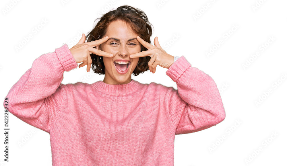 Young hispanic woman wearing casual clothes doing peace symbol with fingers over face, smiling cheerful showing victory Young hispanic woman wearing casual clothes doing peace symbol with fingers over face, smiling cheerful showing victory