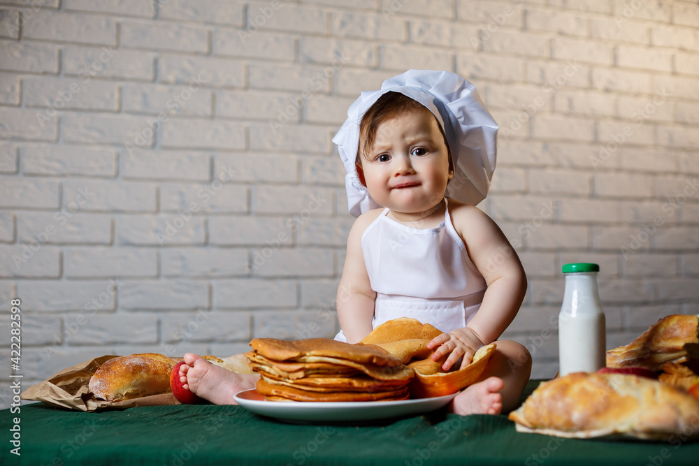Little chef. Little kid dressed as a chef with pastries, buns, bread Little chef. Little kid dressed as a chef with pastries, buns, bread