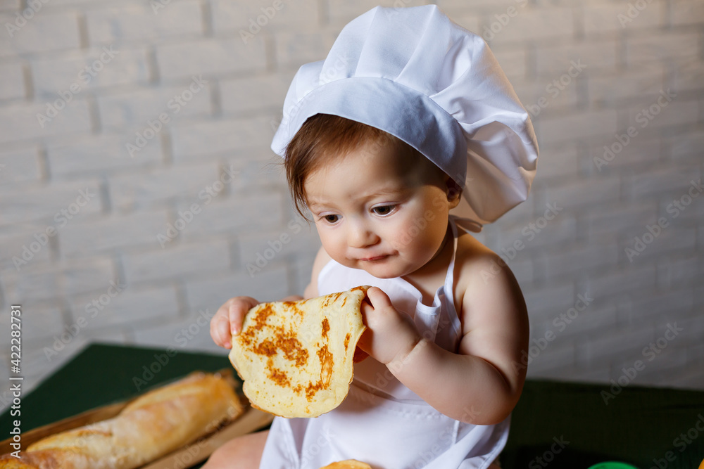 Little chef. Little kid dressed as a chef with pastries, buns, bread Little chef. Little kid dressed as a chef with pastries, buns, bread