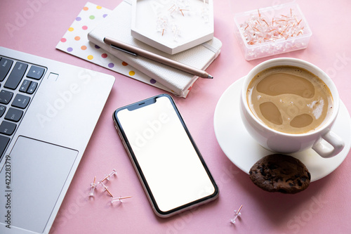 Lady freelancer's home pastel pink workplace, cup of coffee and smartphone mock-up