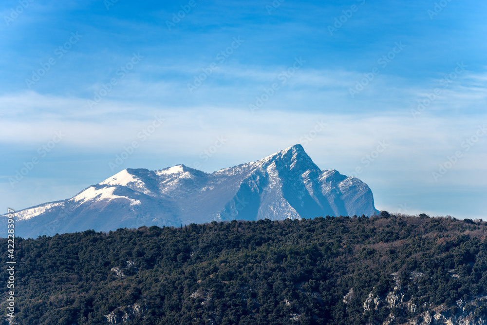 Mountain Peak of Monte Pizzocolo in winter with snow, also called the nose or the head of Napoleon, because his profile resembles that of the famous emperor. coast of the Lake Garda, Lombardy, Italy.