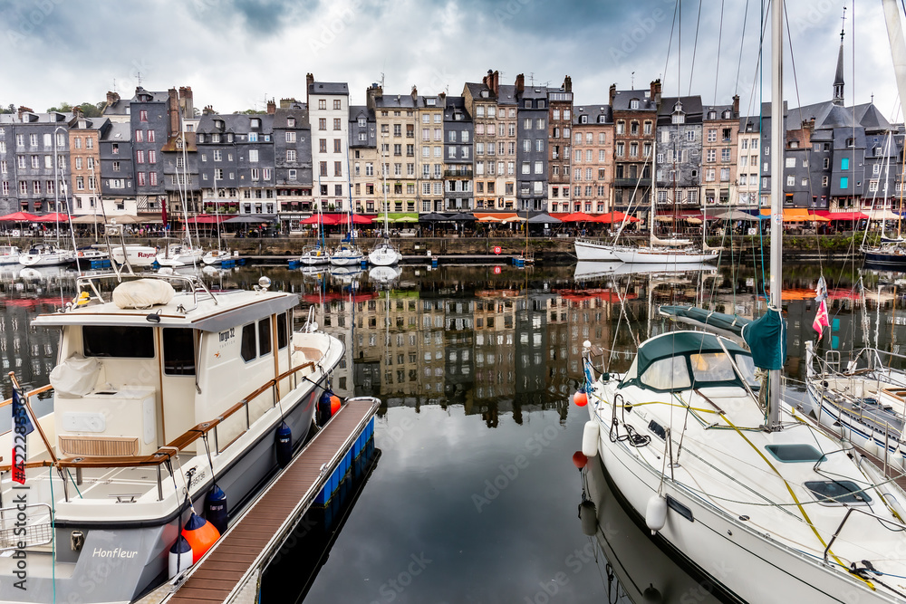 Honfleur, Normandy / France - August 27, 2020. World heritage in Calvados, Normandy, France. Panoramic view of the picturesque harbour of Honfleur, yachts and old houses reflected in water.