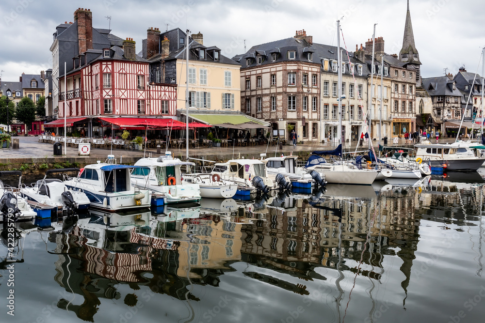 Honfleur, Normandy / France - August 27, 2020. World heritage in Calvados, Normandy, France. Panoramic view of the picturesque harbour of Honfleur, yachts and old houses reflected in water.