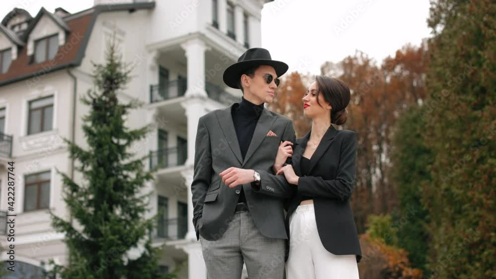 A man and a woman are standing and looking at each other. They are smiling. They are stylishly dressed. 4K A man and a woman are standing and looking at each other. They are smiling. They are stylishly dressed. 4K