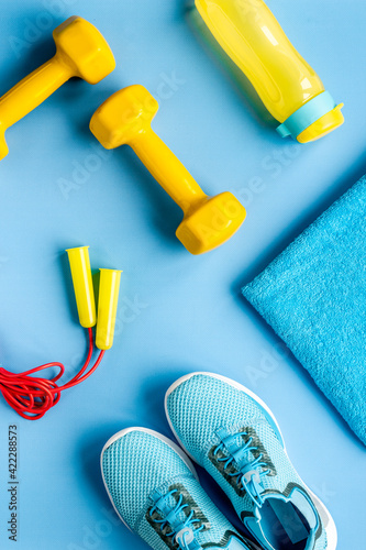 Flat lay of sport fitness equipments with sneakers and dumbbells