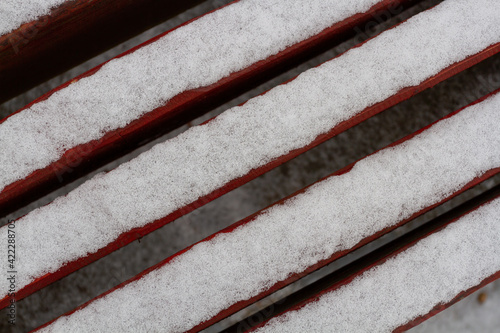 The brown boards are covered with a thin layer of grainy snow. Diagonal composition.