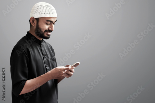 Religious asian muslim man use handphone