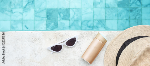 Foto white sunglasses, sunscreen bottle and hat near swimming pool in luxury hotel