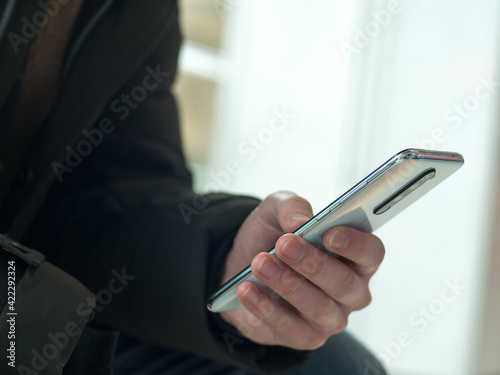 Man using smartphone. Close up of hand dolding phone.