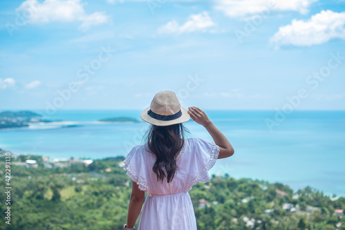 Happy traveler woman enjoy Koh Samui view point, alone Tourist standing and relaxing over ocean in Southern Thailand. Southeast Asia travel, trip and summer vacation concept